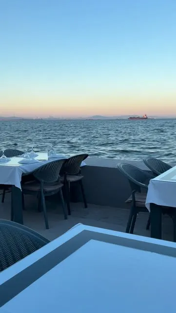 Gün batımında deniz manzaralı masalar